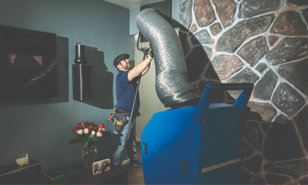 Forever Vent technician connecting duct cleaning equipment inside a Phoenix home